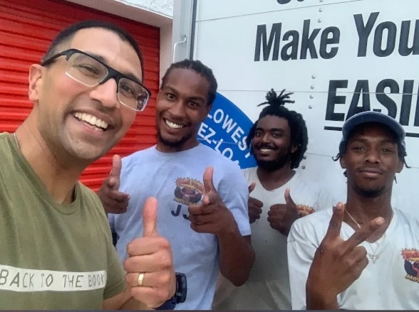 The DynaMight Movers crew on a moving day in Florida, smiling beside the truck.